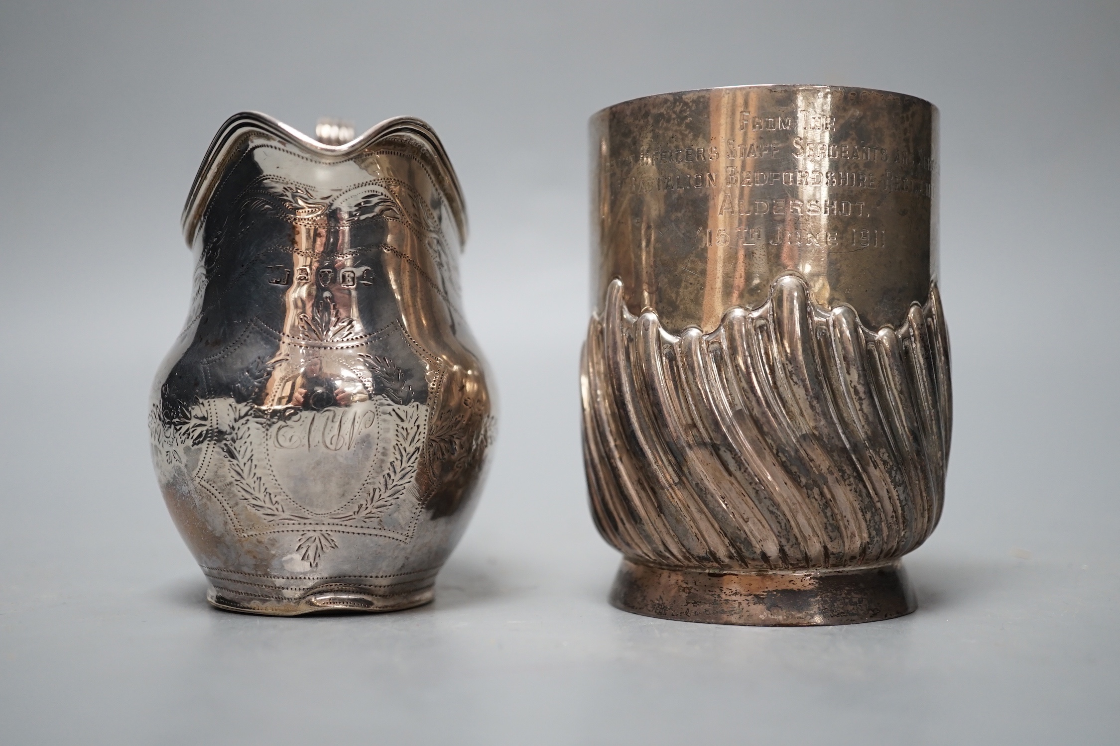 A George III silver cream jug, London, 1800, a later silver mug and a white metal and enamelled initiallled clip?, gross 8.5oz.
